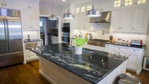 svart bänkskiva och vitt kökskåpp i köket